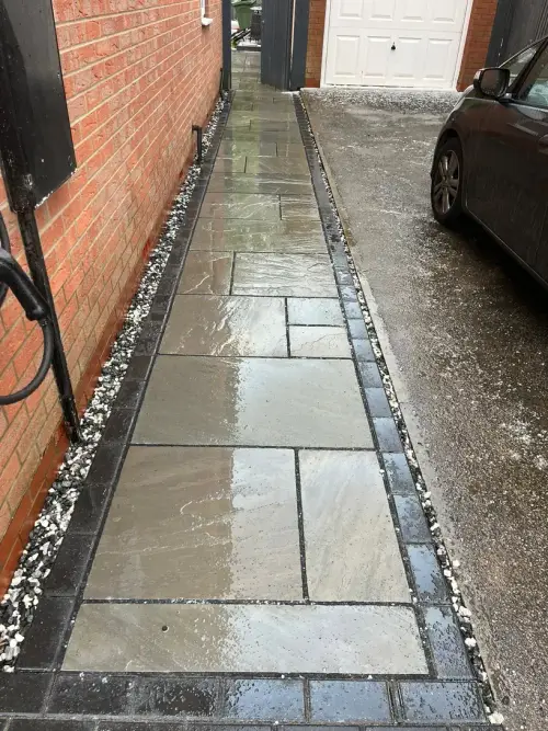 Grey slab side path with block edging and gravel